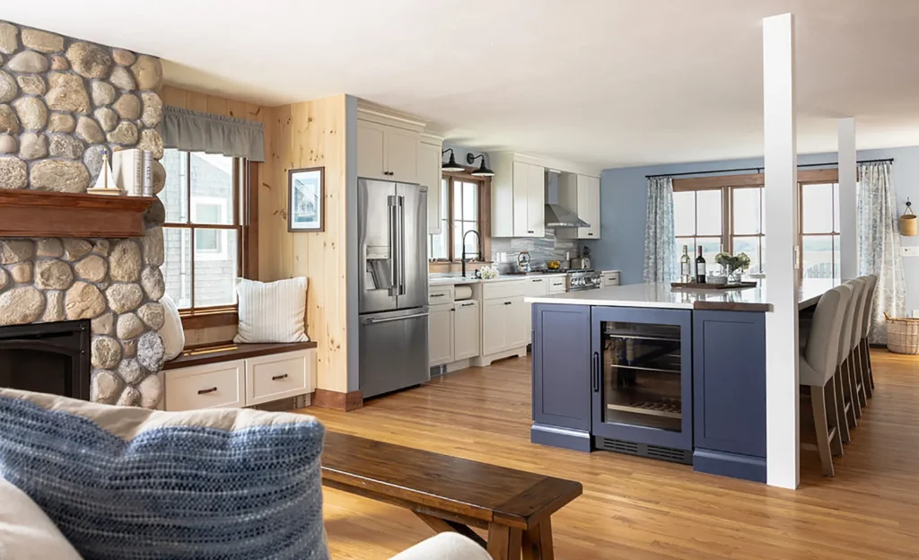 This first-floor renovation features a custom fireplace, remodeled kitchen with custom cabinetry, large kitchen island, and new windows.