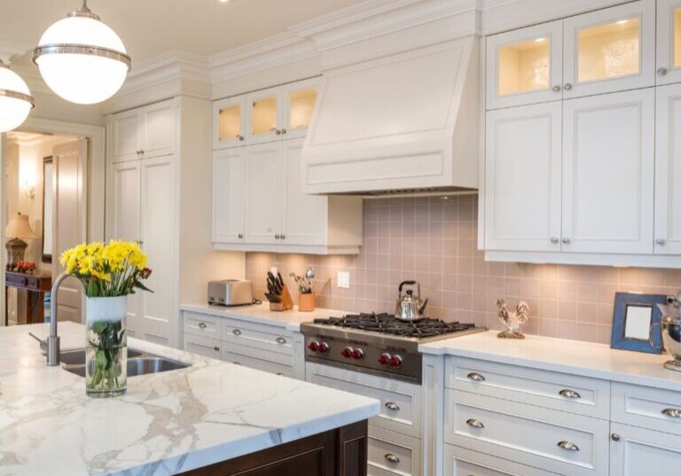 Kitchen remodel with white cabinets, tile backsplash and matching hood vent